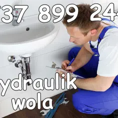 Hydraulik w Stalowej Woli przy umywalce, notuje coś na kartce. Telefon: 737 899 244.
