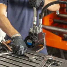Specjalista montuje elementy hydrauliki siłowej w Grójcu. Widać narzędzia i przewody.