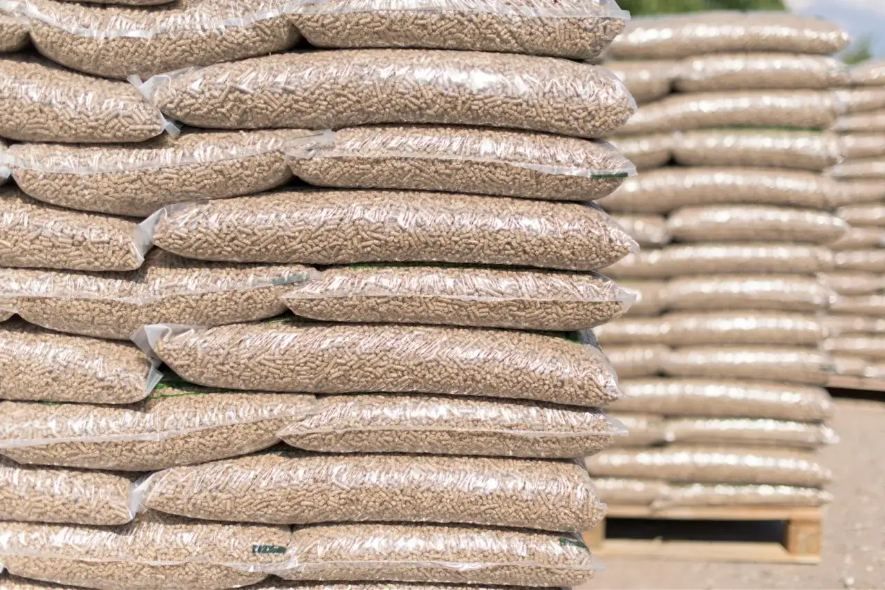 Stosy worków z pelletem drzewnym. Zastanawiasz się, ile kosztuje tona pelletu? Oto odpowiedź w postaci zapasów gotowych do sprzedaży.